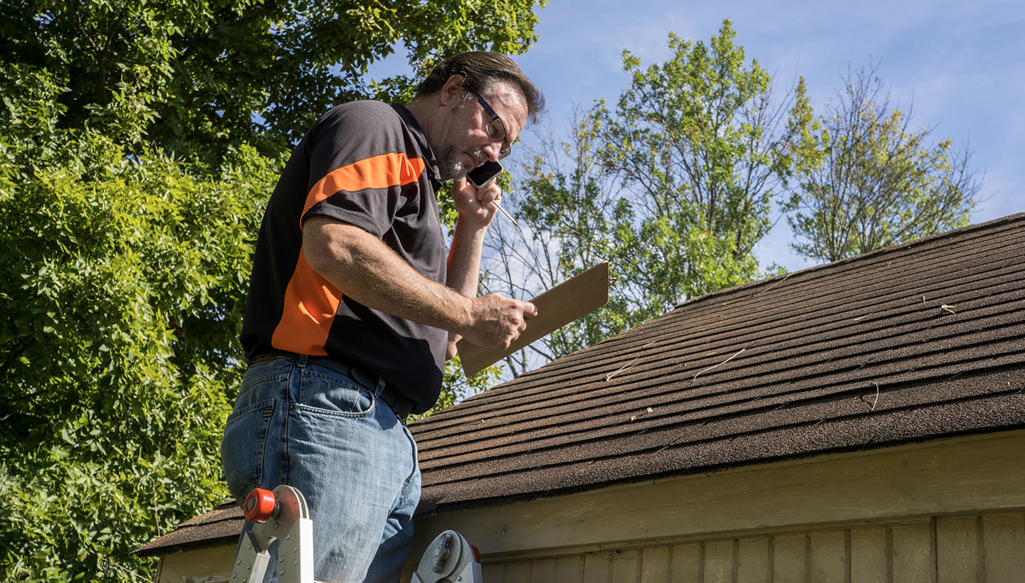 home inspector inspecting roof with clipboard