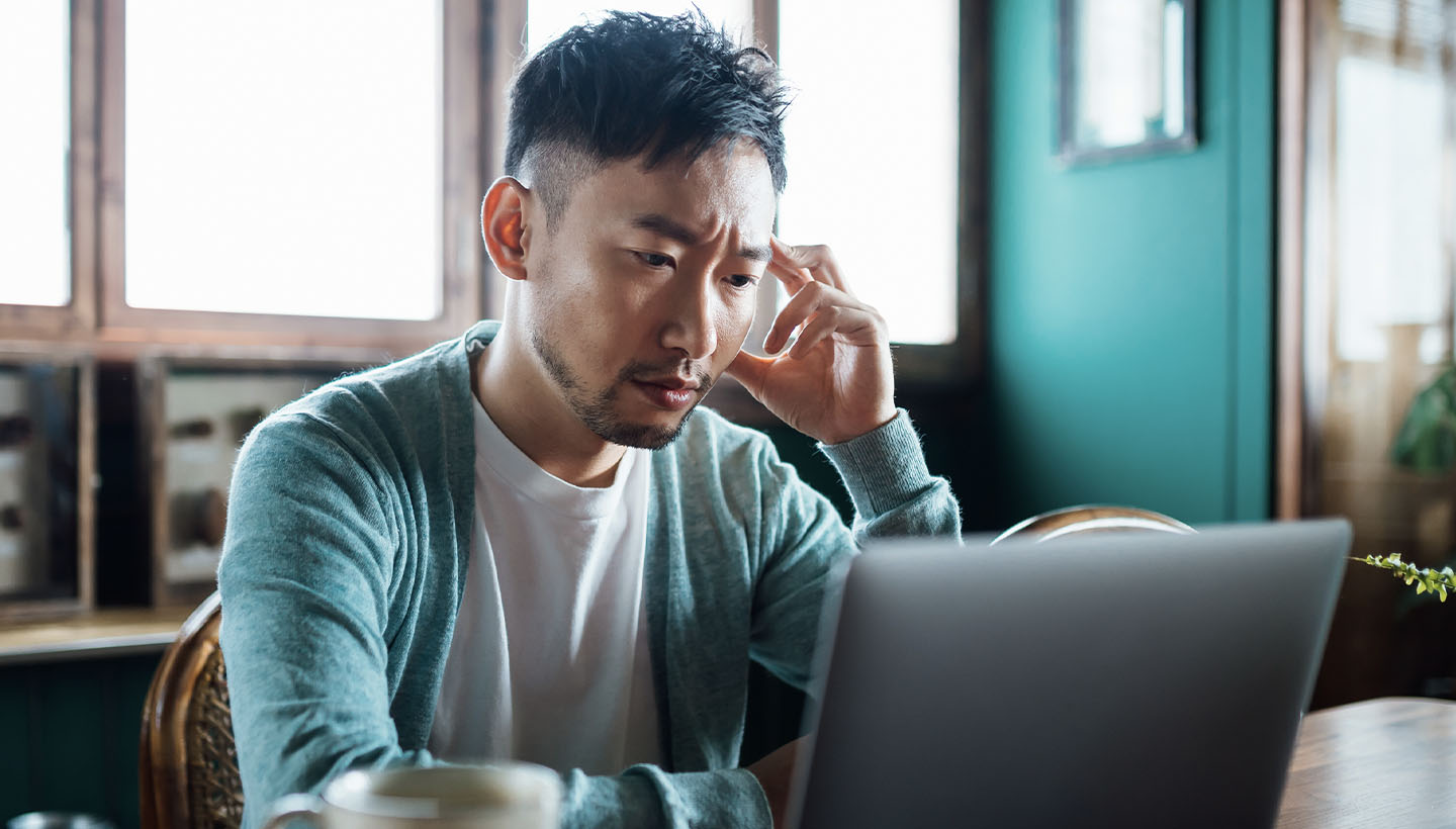 a home inspector, appearing disappointed, stares at a laptop screen