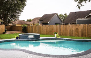 a residential swimming pool in a fenced in backyard