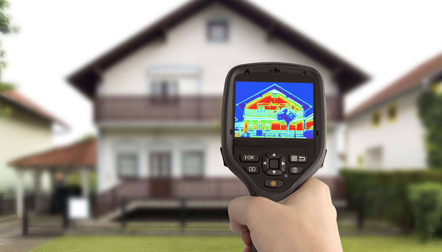 person holding a thermal imaging camera and using during a thermal imaging inspections