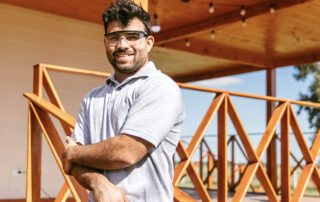 A home inspector stands in front of a wooden deck before performing a deck inspection.