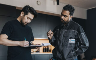 A home inspector and a client reviewing a report. The inspector needs tips for avoiding omissions in home inspection reports